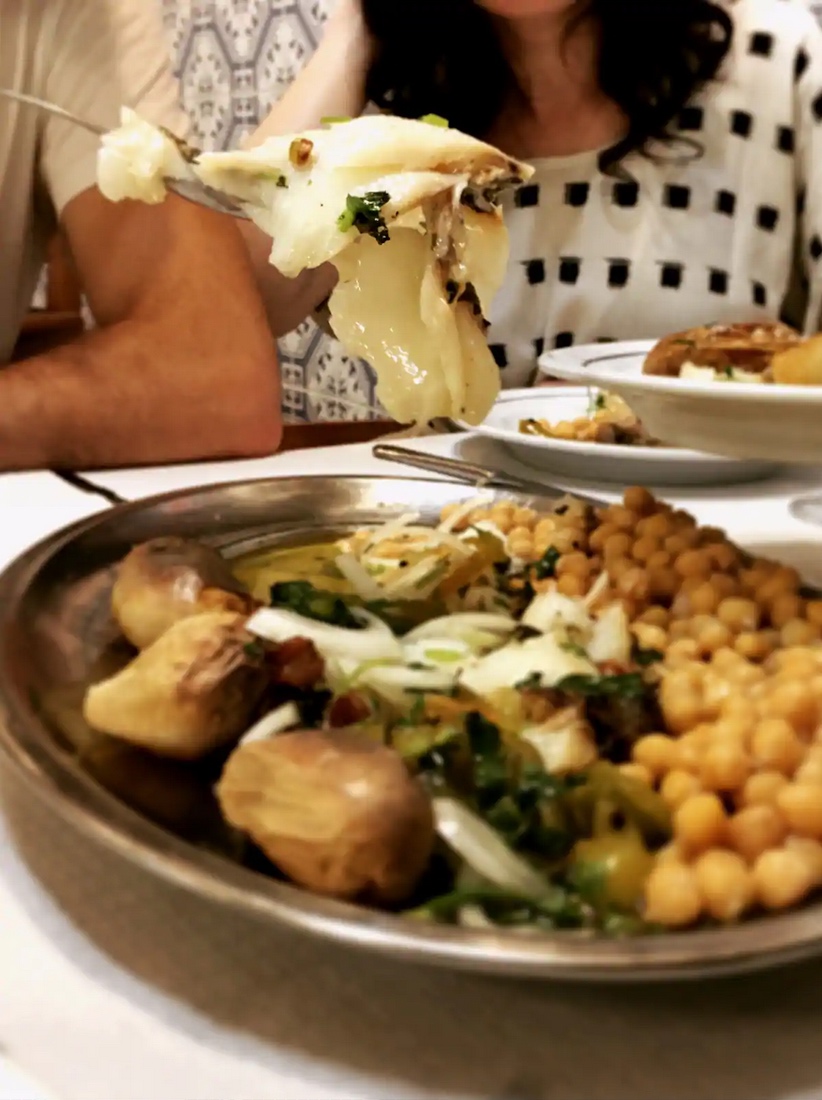 a woman sitting at a table with a plate of food