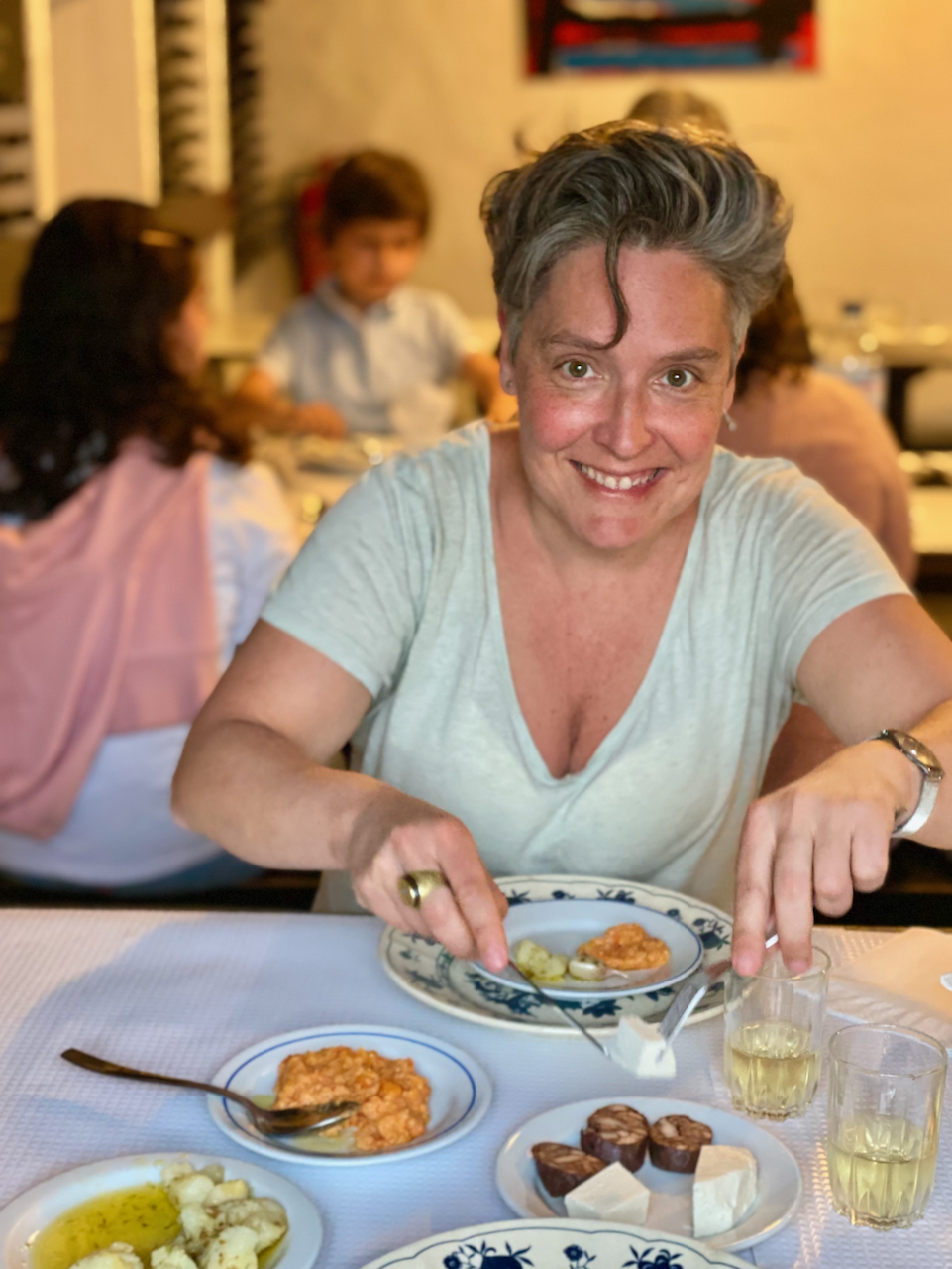 a woman sitting at a table with a plate of food