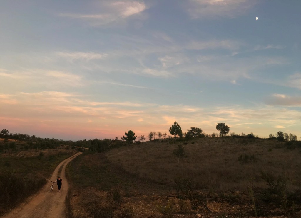 a sunset over a grass field