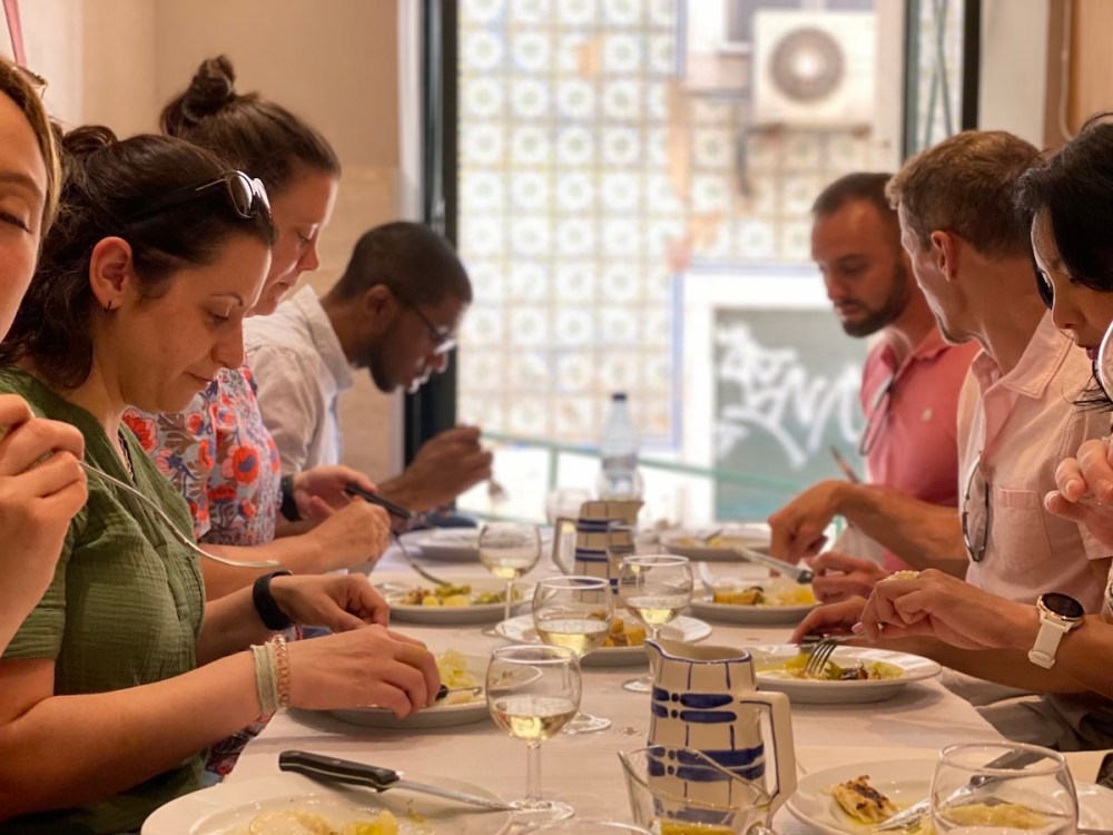 a group of people sitting at a table eating food