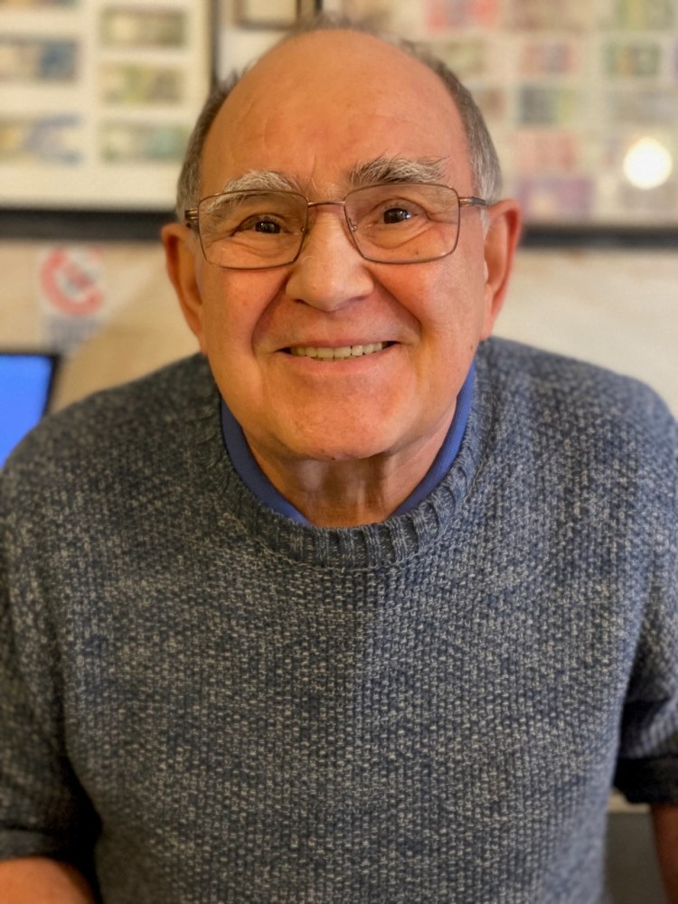 a man wearing glasses and smiling at the camera