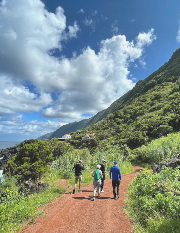 a group of people walking down a dirt road