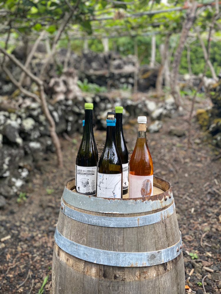 a bottle of wine sitting on top of a barrel